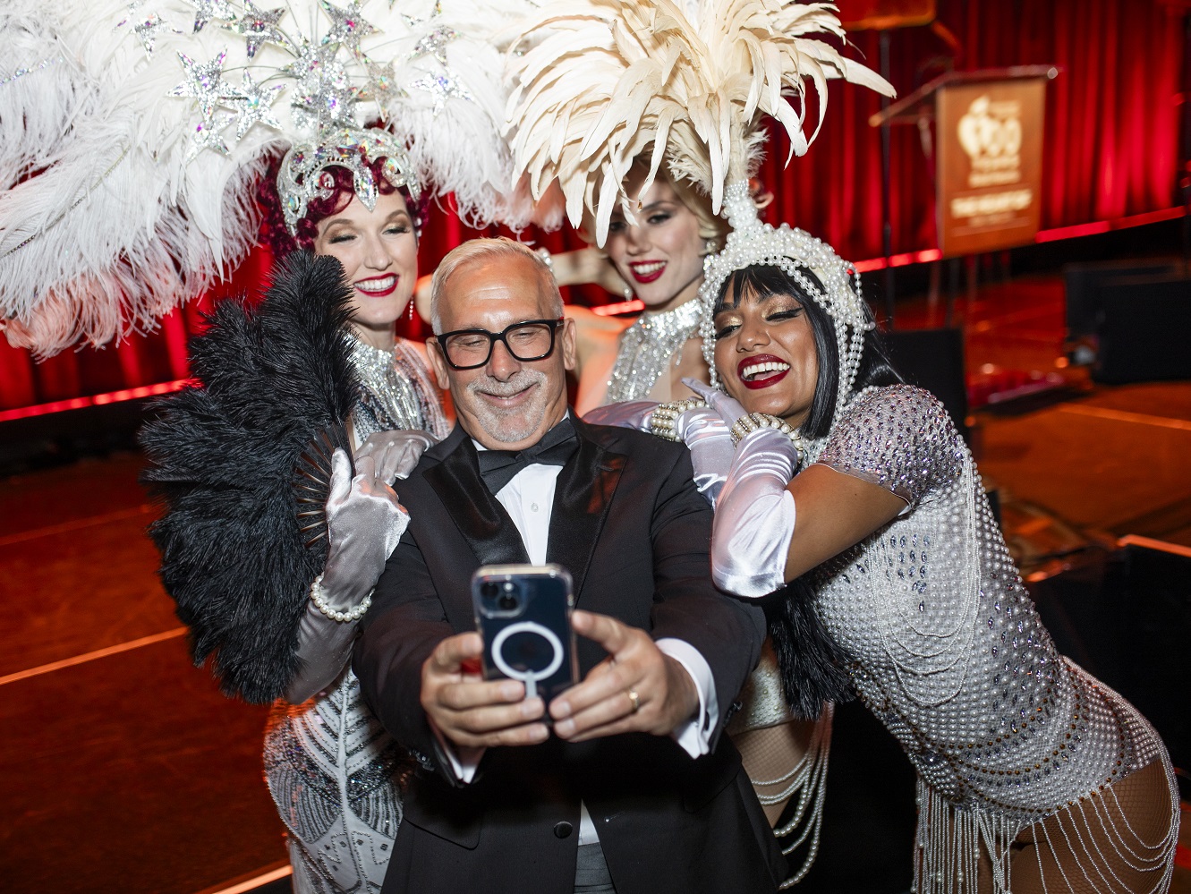 Smiling man taking selfie with three performers